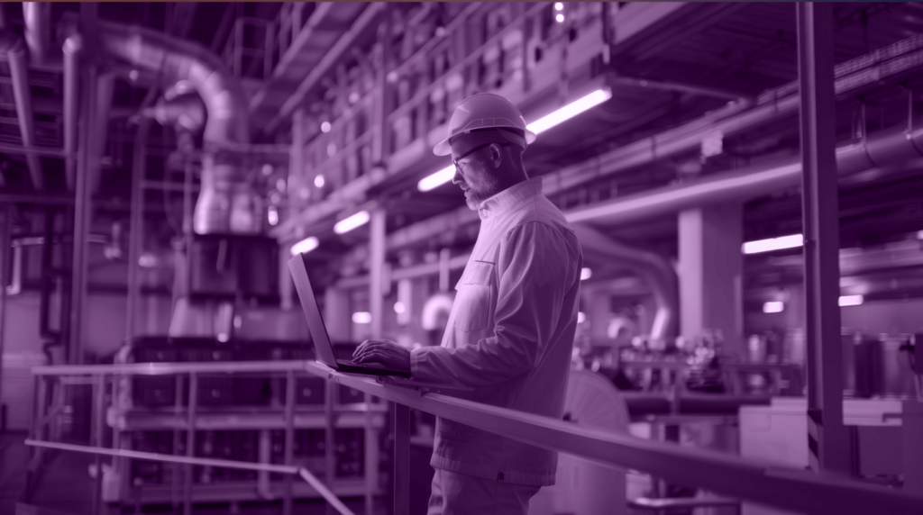 An image featuring a man working on his computer in the industrial setting