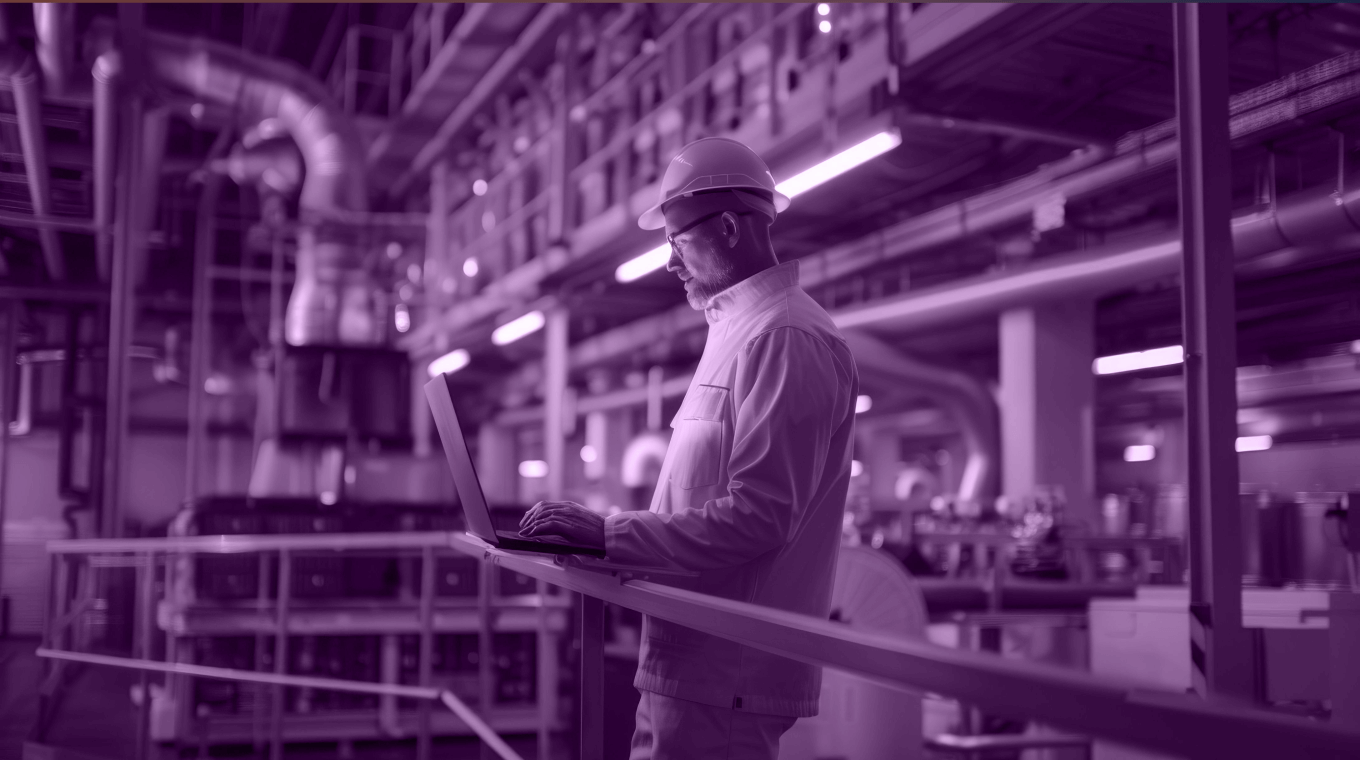 An image featuring a man working on his computer in the industrial setting